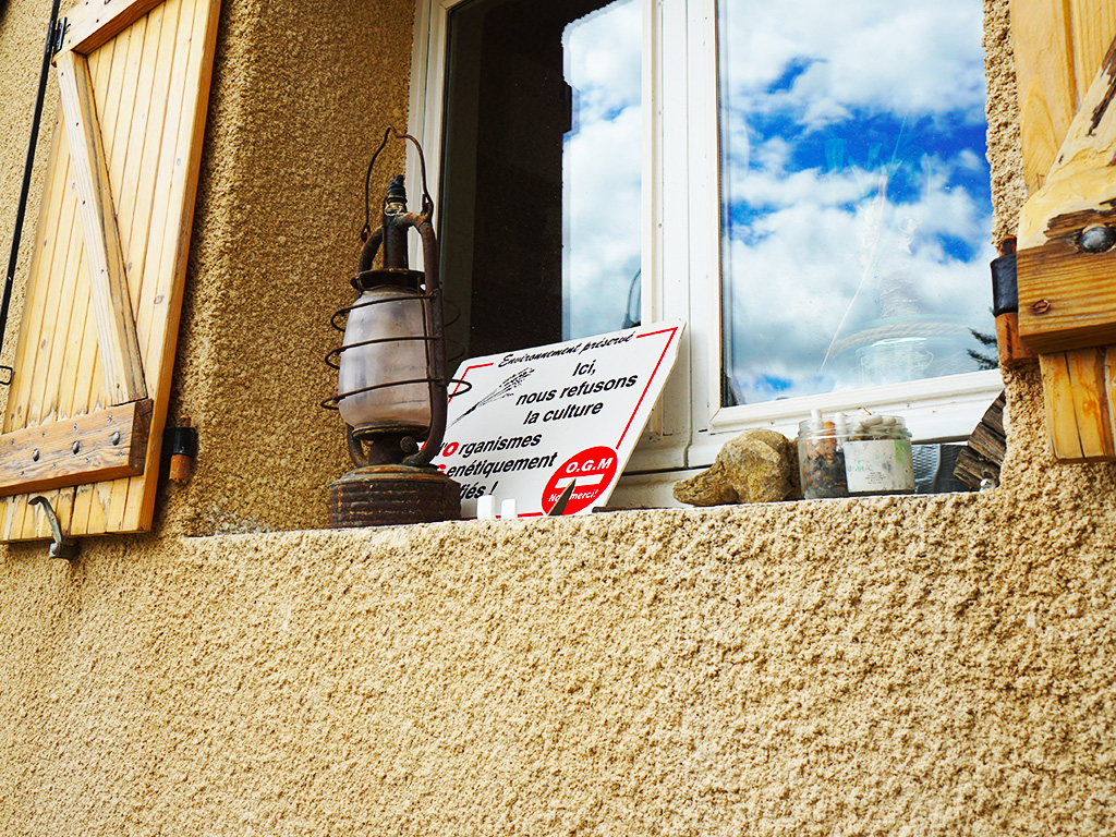 Une pancarte anti OGM posée devant une fenêtre du Treuil